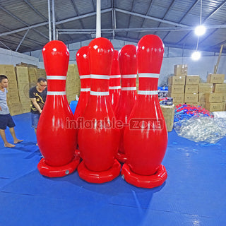 Giant red inflatable human bowling pins in a factory
